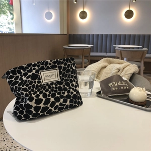 Canvas makeup bag with black and white cow print and Time to Party woven label
