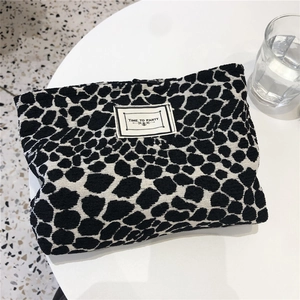 Detailed macro view of the textured black and white spotted canvas makeup bag fabric