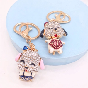Sparkling zodiac pig keychains with rhinestones and enamel on a blue display stand