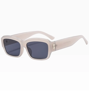 Macro shot of rectangular sunglasses featuring cream frames and silver metal hinge accents