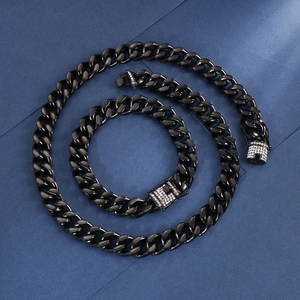 Detail of black cuban link chain set with sparkling zircon pavé clasps on dark backdrop
