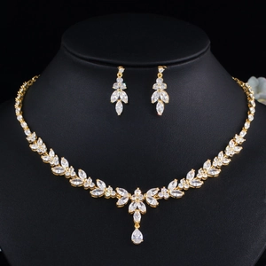 Close-up of golden marquise cubic zirconia necklace and earrings set on black velvet