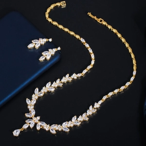 Detailed close-up of golden floral leaf jewelry set with sparkling AAA zircon stones