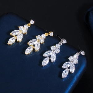 Macro shot of silver and gold zircon leaf earrings with sparkling faceted crystal cluster