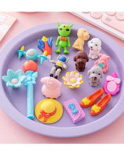 Close-up of colorful detachable cartoon erasers in space and fashion shapes on a tray