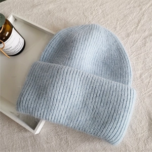 Detailed close-up showing the soft plush texture of the light blue knitted beanie hat