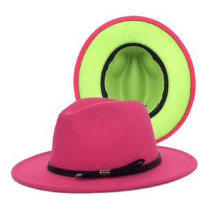 Detail of fedora hat with fuchsia exterior, neon green lining and black leather band