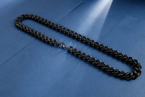 Close-up of a glossy black titanium steel cuban chain necklace with a lobster clasp