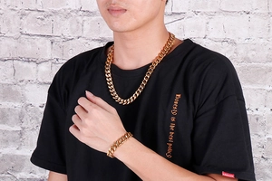 Close-up of golden Cuban link chain necklace and bracelet set on a male model