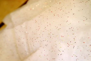 Detailed macro view of white artificial Christmas snow with colorful glitter sequins