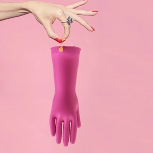 Pink rubber household gloves with orange hanging hook shown against a pink background