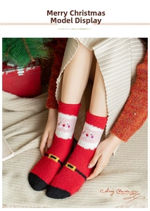 Detail of red Christmas coral fleece socks with cute Santa Claus plush pattern design
