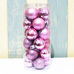 Close-up of pink Christmas balls with matte and glossy finishes in a clear storage tube