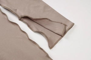 Close-up of split sleeve cuff detail with contrast stitching on brown slim dress