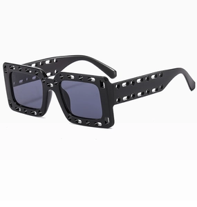 Detail einer quadratischen, hohl gestalteten Sonnenbrille in mattschwarz mit Gläsern