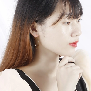 Chic gold wavy hoop earrings for women showing modern textured style on a model