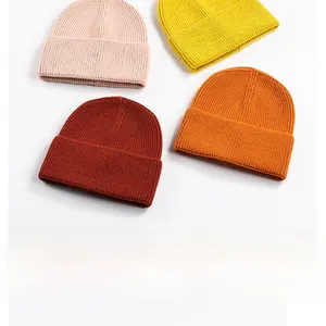 Detailed knit texture of cuffed beanies in pink, yellow, red and orange colors