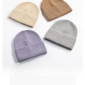 Flat lay of ribbed knit beanies in cream, brown, grey, and lavender colors