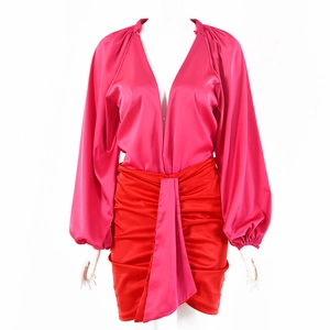 Set camicetta di raso rosa con scollo a V e minigonna a pieghe rossa su manichino bianco