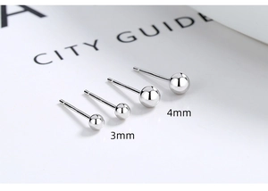 Detailed close-up of 3mm and 4mm S925 sterling silver ball studs on a magazine