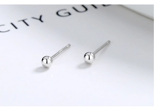 Macro detail of minimalist S925 sterling silver ball studs showing high-polish finish