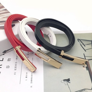 Close-up of thin leather belts in red, white, and black with shiny gold buckles
