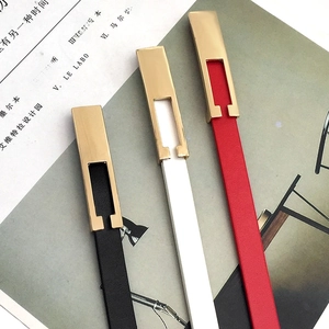 Detailed view of slim black, white, and red leather belts with polished gold buckles