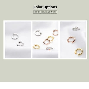 Detail of 925 sterling silver hoop earrings with colorful zircon stones on silk