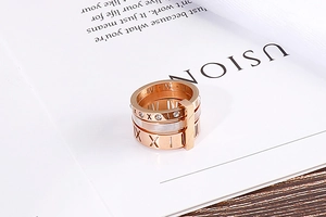 Detail of rose gold multi-layer ring featuring Roman numerals and zircon stones