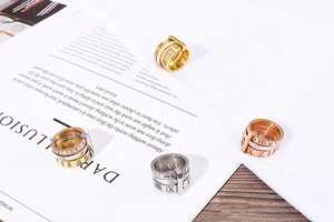 Close-up of polished stainless steel rings with Roman numerals and diamond accents