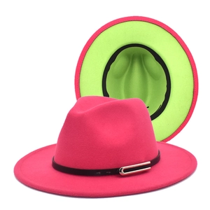 Detail of fuchsia fedora hat with wide brim, black leather band, and neon green underside