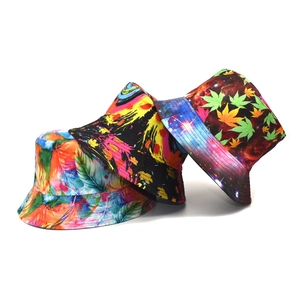 Three vibrant printed bucket hats featuring feather, graffiti, and maple leaf patterns