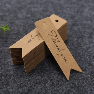 Brown kraft paper swallowtail gift tags with Thank You print on grey felt background
