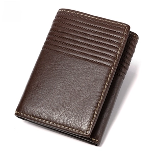 Close-up of brown genuine leather texture with RFID blocking shield logo and fine stitching