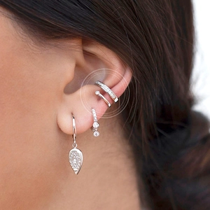 Gros plan d'un earcuff argenté à double rangée avec oxydes de zirconium sur l'oreille