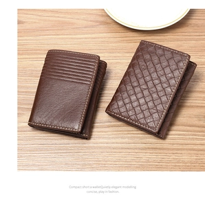 Detail view of deep brown leather wallets with woven texture on a wooden background