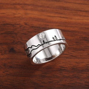 Minimalistische zilveren ring met berg- en bosgravure en een sprankelende zircon