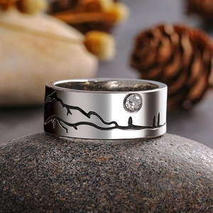 Brede zilveren ring met bergreliëf en zirkoon op een natuurlijke kiezelsteen