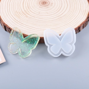 Detail of butterfly silicone mold for resin casting with a glittery green finished pendant