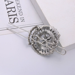 Close-up of vintage silver hair pin featuring a hollow turquoise flower pattern