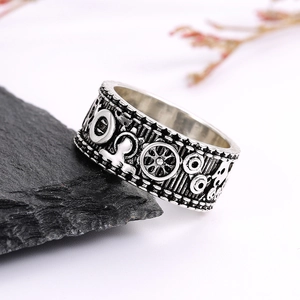 Retro Steampunk Zahnring mit Silber-Finish und mechanischem Relief auf dunklem Fels