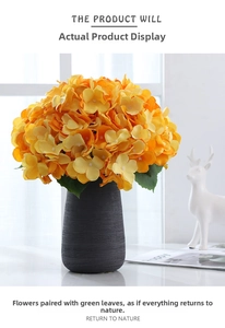 Close-up of orange artificial hydrangea in a textured black ceramic vase for home decor