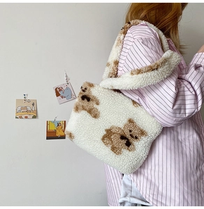 Close-up of soft white faux fur tote bag featuring a cute brown bear print and shoulder strap