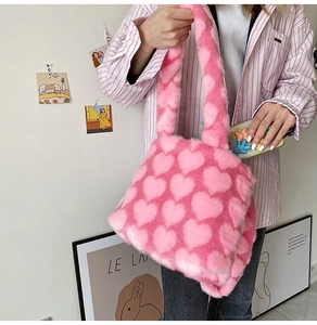 Detail of pink faux fur tote bag showing plush texture and heart pattern in a lifestyle shot