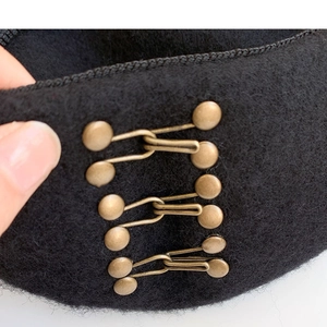Classic black wool beret hat with vintage bronze metal buckle fasteners in retro style