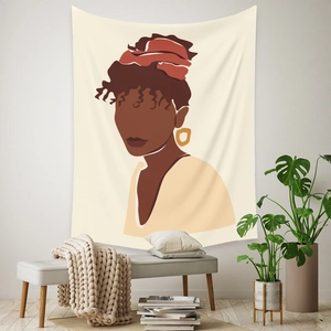 Detail of bohemian wall tapestry featuring a minimalist portrait of an African woman on a wall