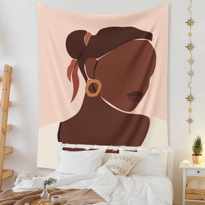 Detail of bohemian wall tapestry featuring abstract female portrait in a cozy bedroom