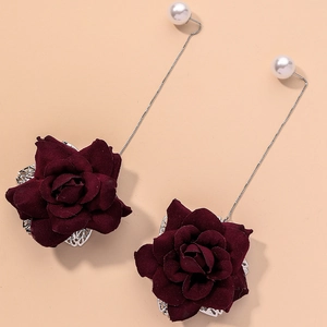 Vintage red fabric rose earrings with white pearls and silver chains on beige background