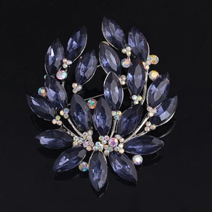 Detail of floral brooch with dark blue marquise gemstones and sparkling crystals