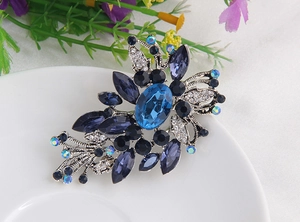 Détail d'une broche fleur vintage avec cristaux saphir bleu sur une base argent antique